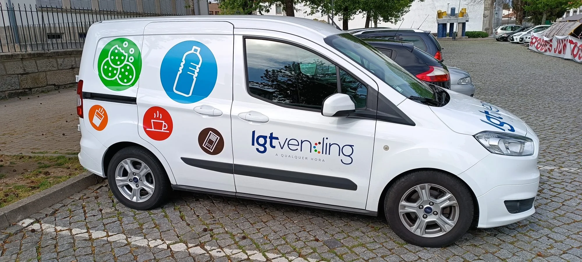 Carrinha branca da LGT Vending com os ícones de café, bebidas, snacks e máquinas